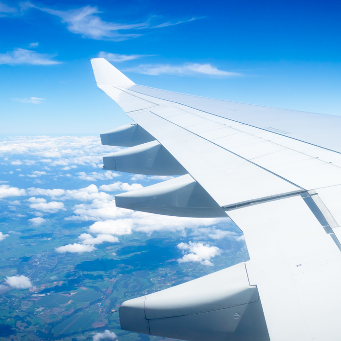 Blue sky with clouds and planes wing. View from planes window