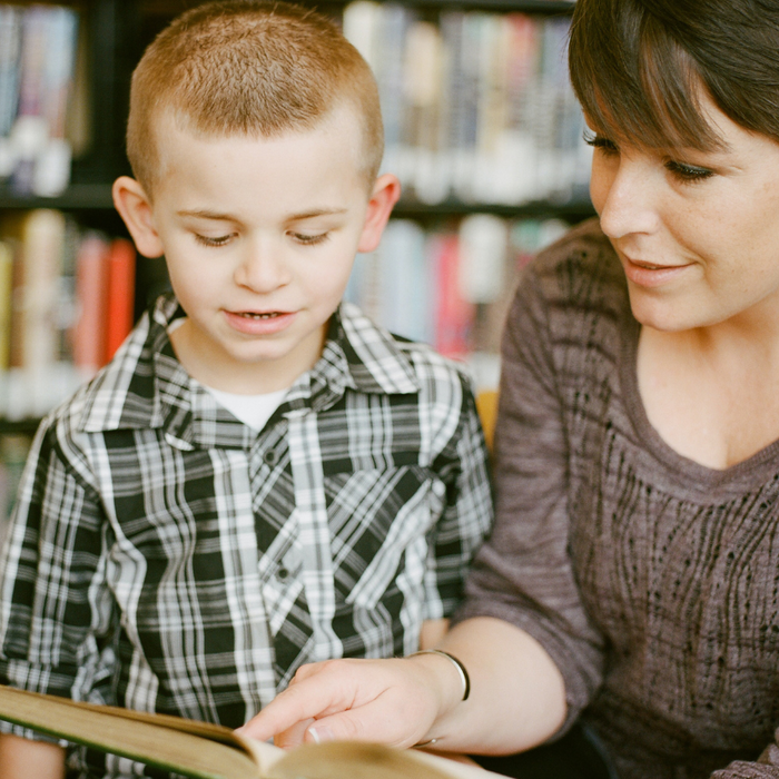 child being read to by woman in library
